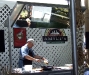 A chef demonstrating cooking with garlic at one of several show tents
