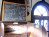 The delightfully misspelled beverage menu, graffiti-carved bench