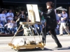 An artist does an oil painting of the parade while he marches