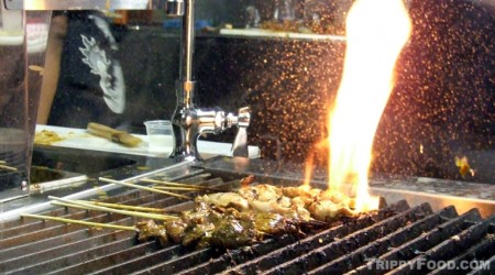 Satay cooking on an open flame