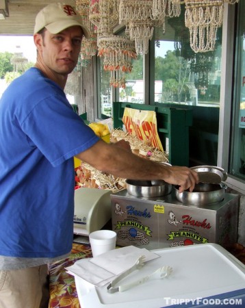 The clerk at Florida Citrus Center scoops a cup of boiled peanuts