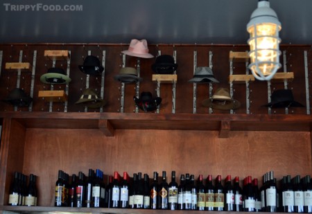 A collection of Larry Bell's signature hats perched above the bar