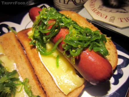 Hot dogs sautéed in cabernet sauvignon over brie and topped with seaweed