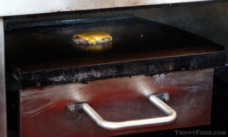 A cheeseburger in progress on Al Cassell's original grill